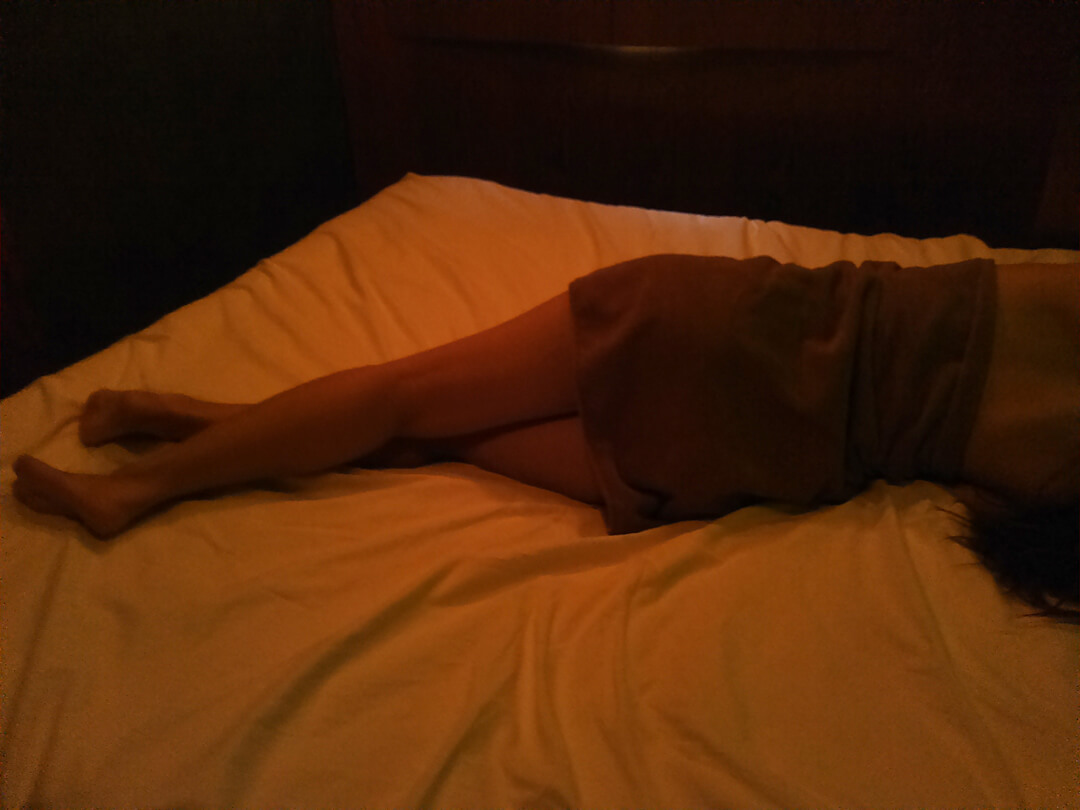 ベッドで伸びをする女性